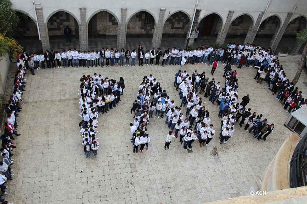 Christliche Schüler in Syrien buchstabieren das Wort „Paix“, „Frieden“ auf Französisch.